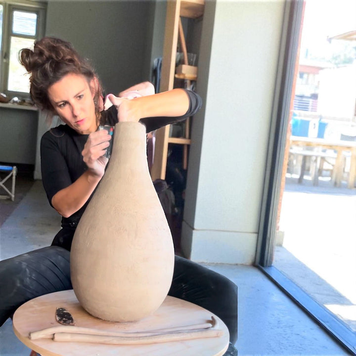 Melissa Bertolino van Klei en Koord uit Menen maakt een keramieken vaas in haar lokale winkel.